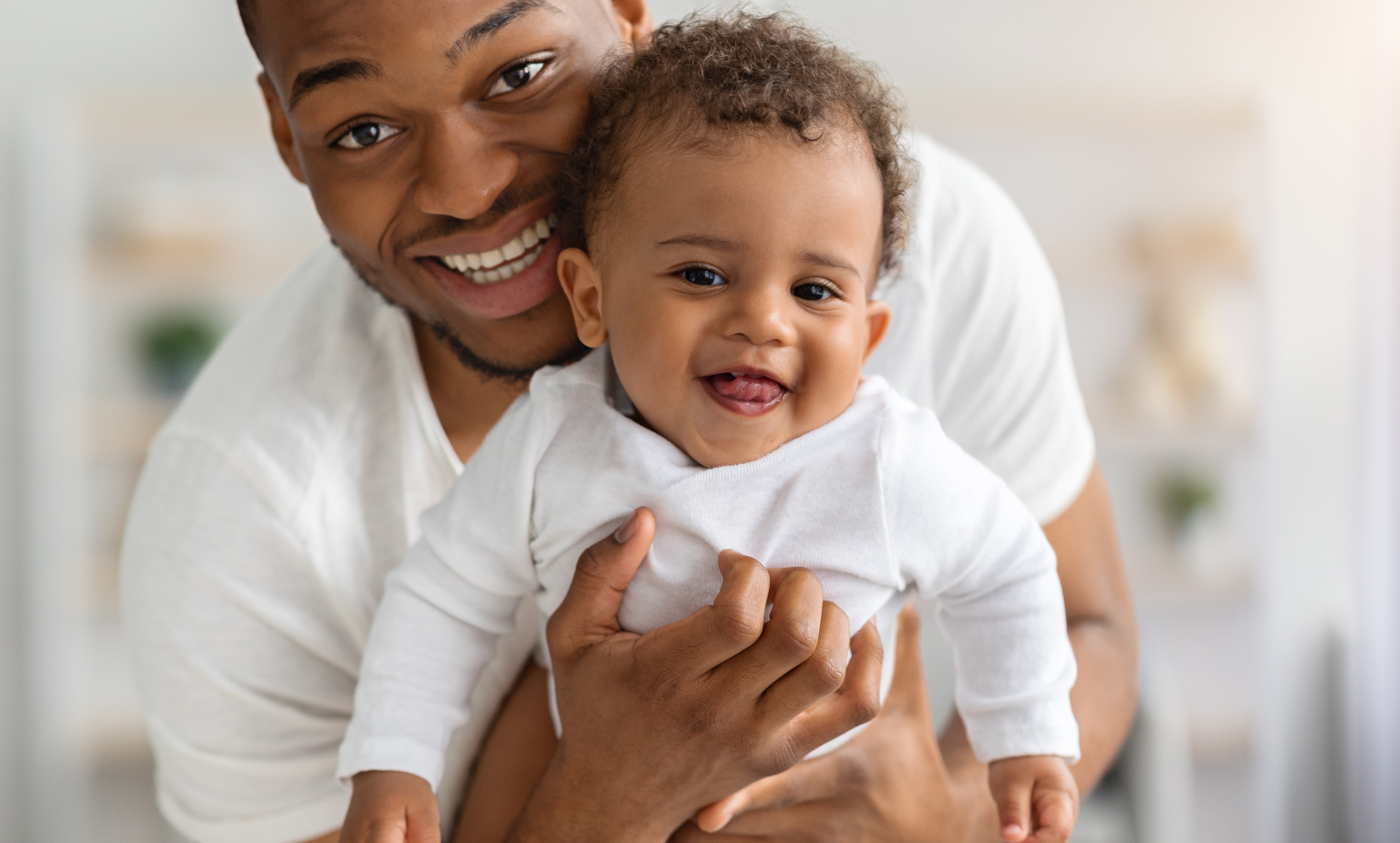 Baby in parent's arms looking at camera